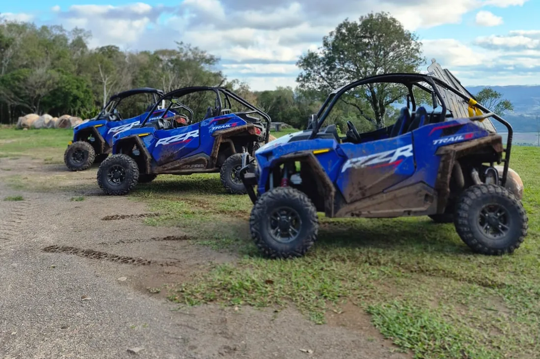 Três Polaris RZR azuis enfileirados no alto da rota