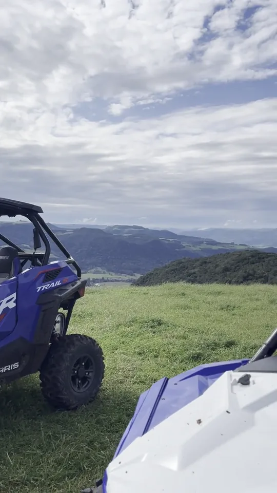 Vídeo vertical de UTVs estacionados no alto, com o vale da Quarta Colônia ao fundo